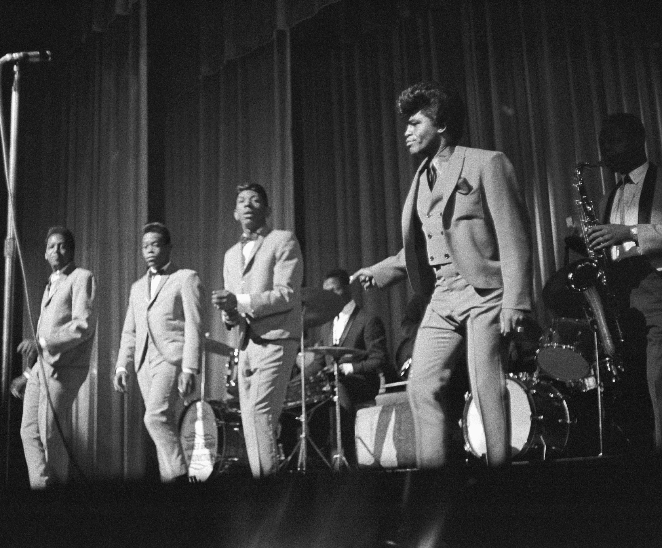 James Brown onstage with the Famous Flames (Johnny Terry, Bobby Byrd, Bobby Bennett) at the Apollo Theater, 1964. Photos via Michael Ochs Archives/Getty Images.